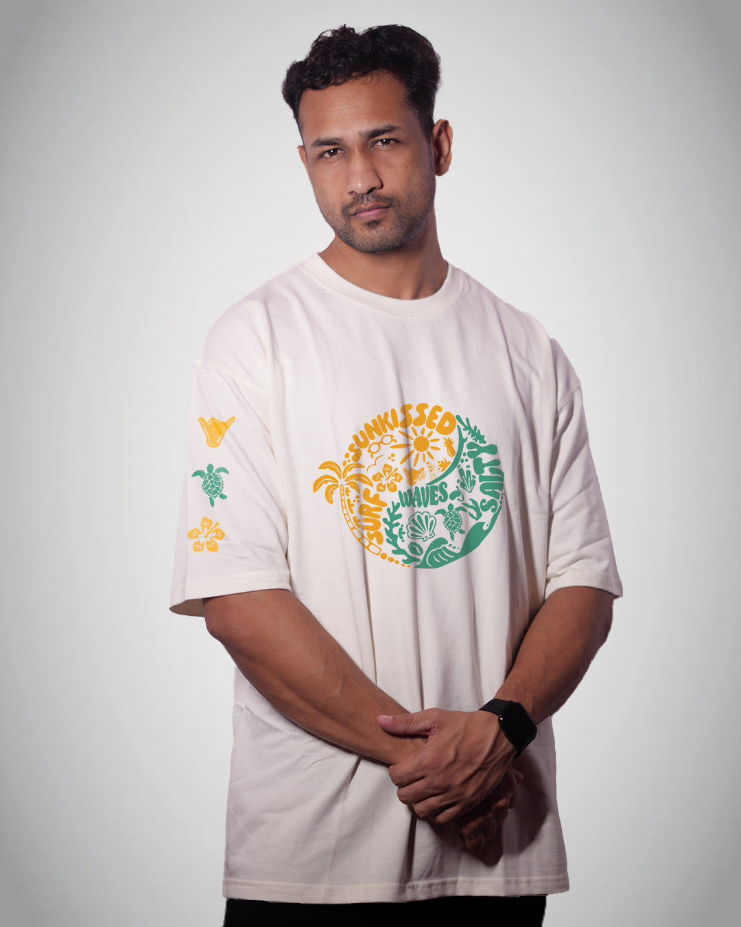 Man wearing a white t-shirt with colorful graphics on a plain background